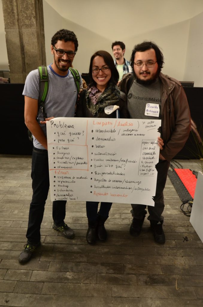 Tres personas sostienen un papel grande con las notas de una sesión de ABRELATAM 2014